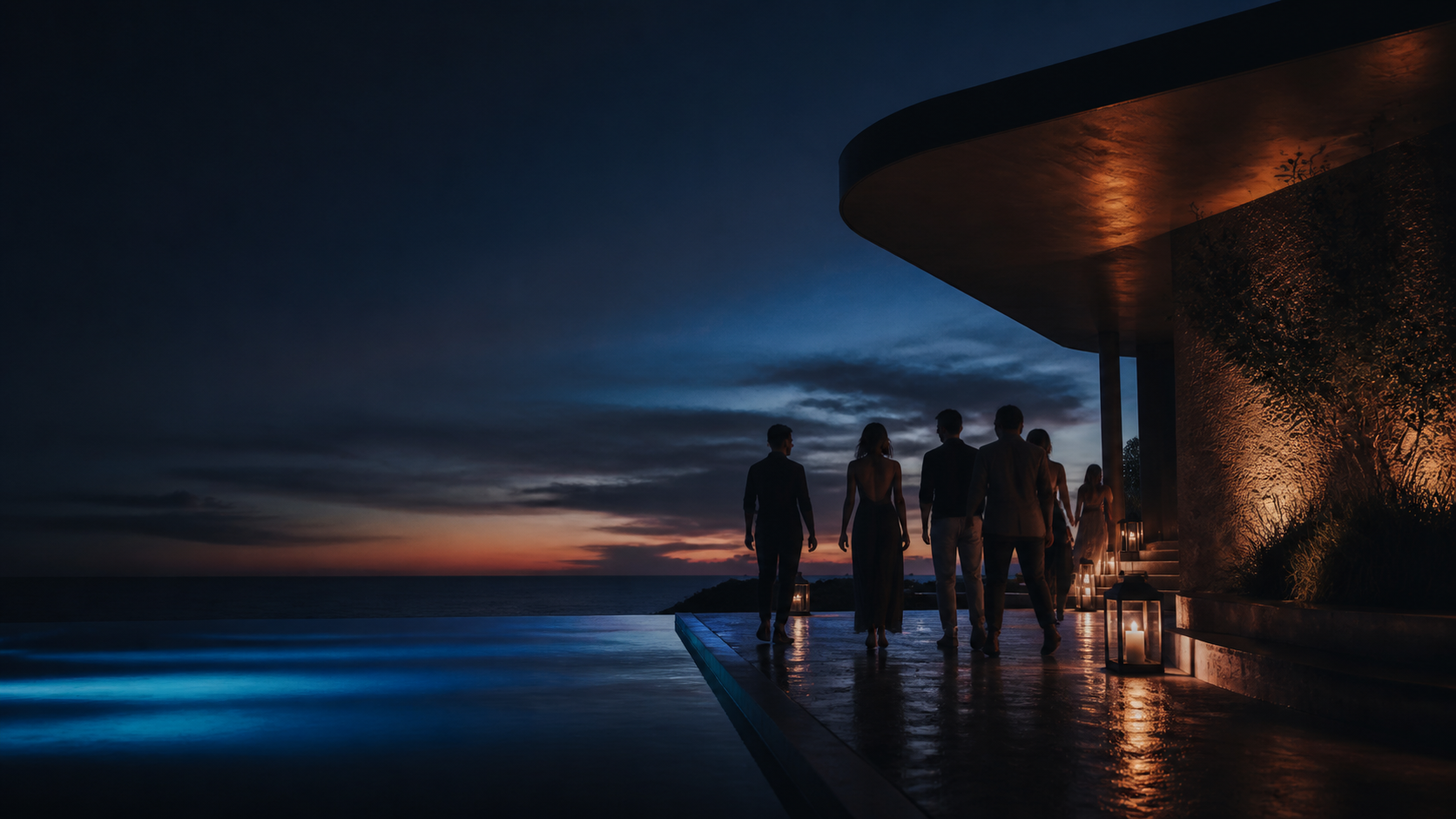 Guests walking beside an illuminated shoreline at dusk